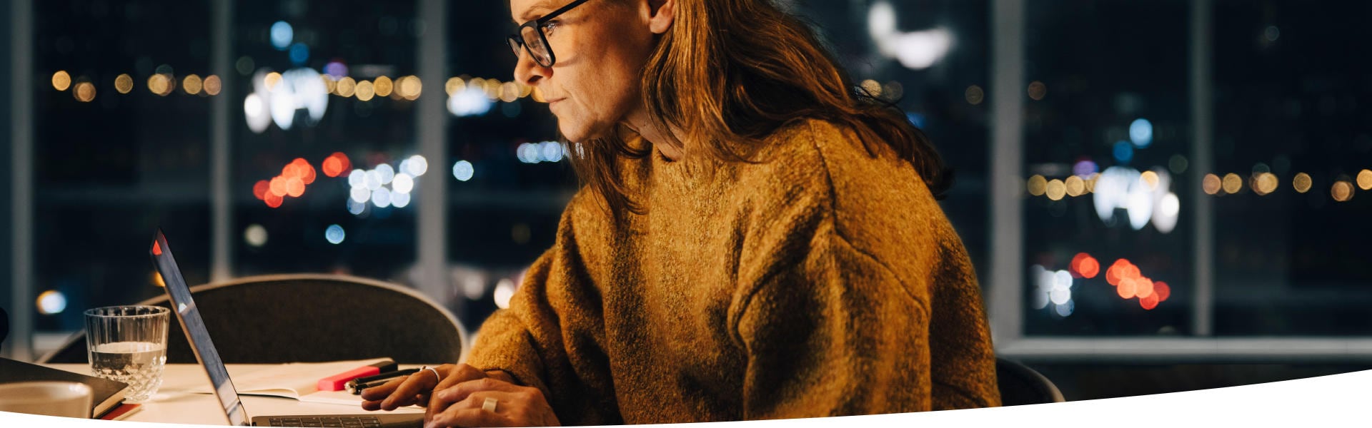 Frau arbeitet spätabends vor dem Laptop