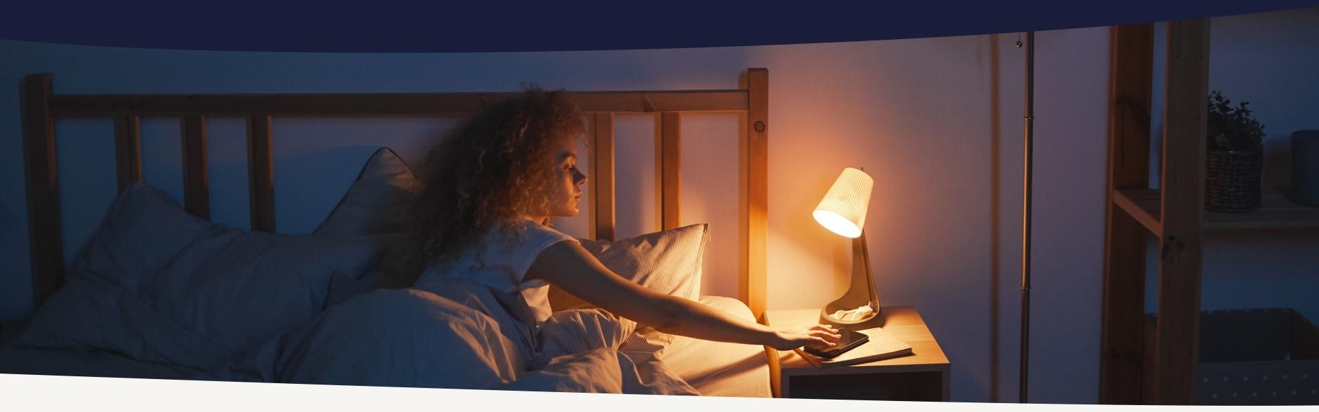 woman turns off the bedside lamp