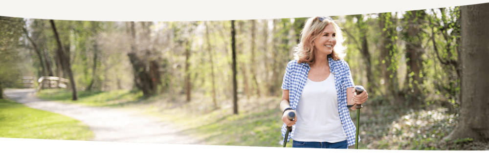 Frau in den Wechseljahren beim Walken in der Natur